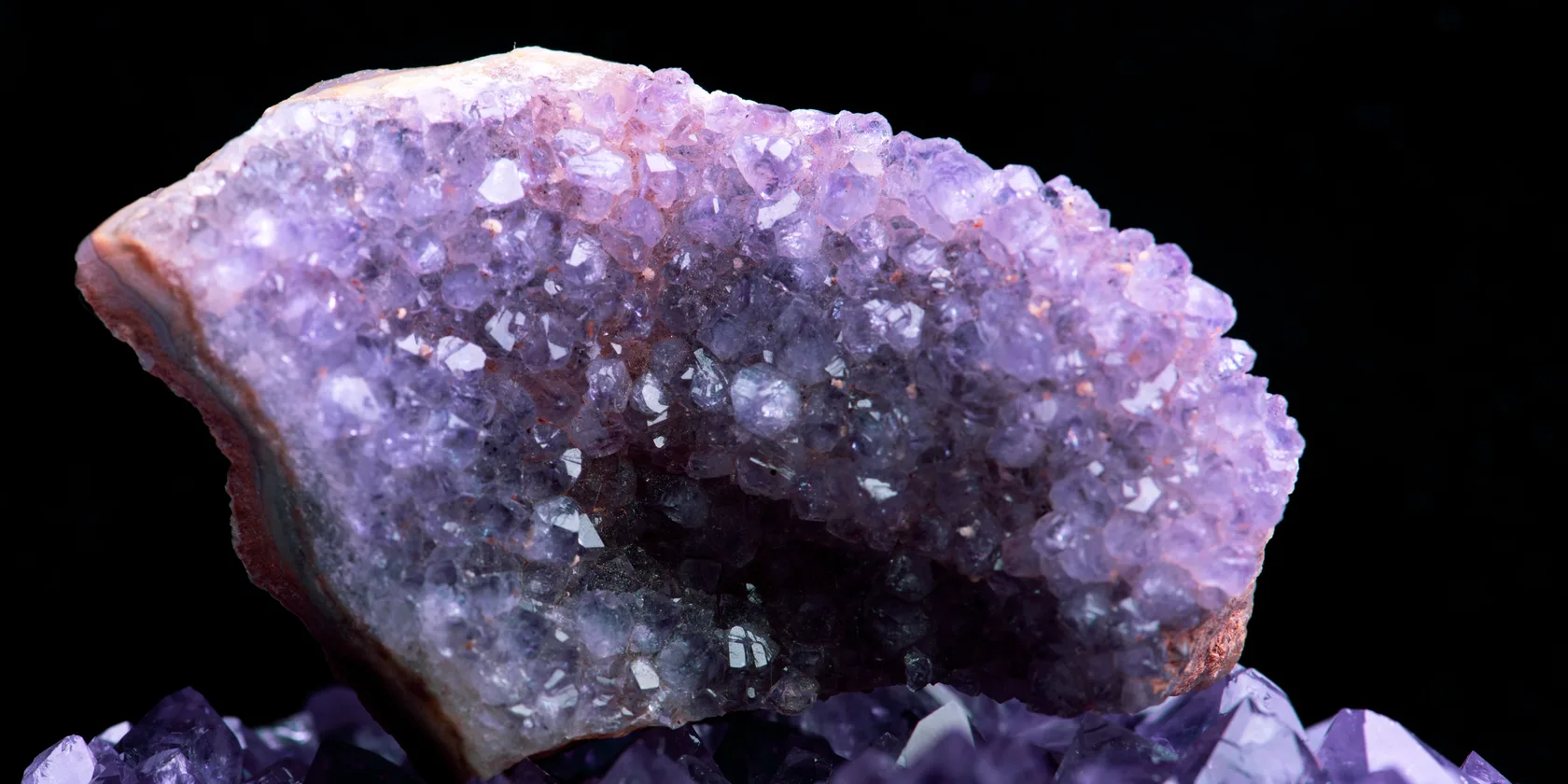 Cristal d'améthyste en gros plan, reflets violets sur fond sombre